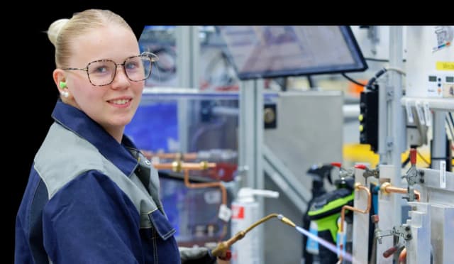 Collaboratrice devant des équipements sur une ligne de production Groupe Atlantic