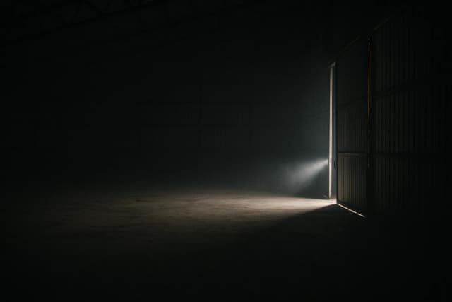 Un bâtiment éclairé par une porte ouverte