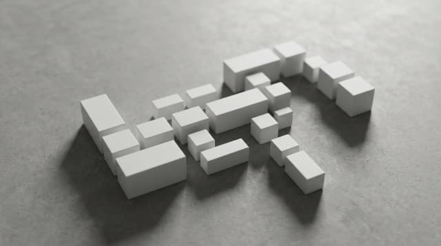 Assemblage minimaliste de petits blocs blancs modulaires sur surface grise béton
