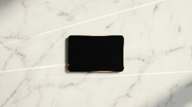 Carte de paiement sombre sur une surface claire, sans inscription visible.
