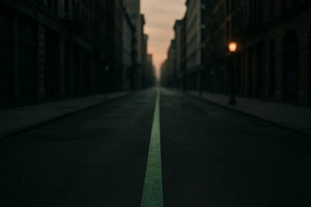 Ligne verte peinte au sol traversant une ville déserte à l'aube, seule signalétique d'un parcours invisible qui s'éloigne entre les façades