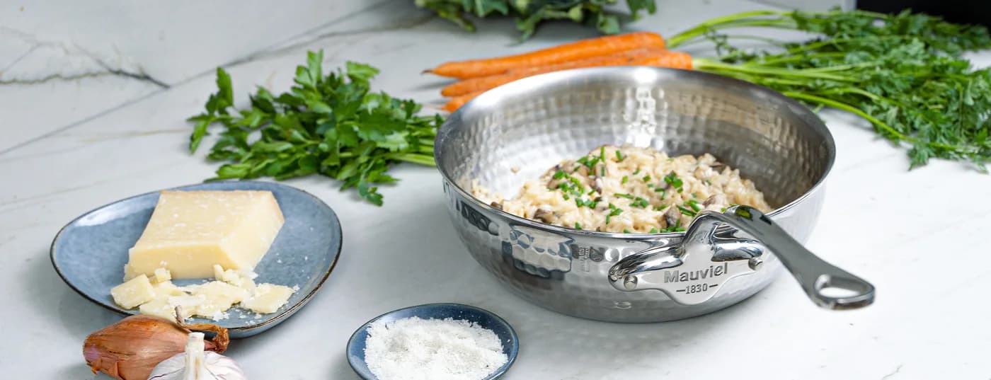Ustensiles de cuisson Mauviel M’Élite et ingrédients sur un plan de travail