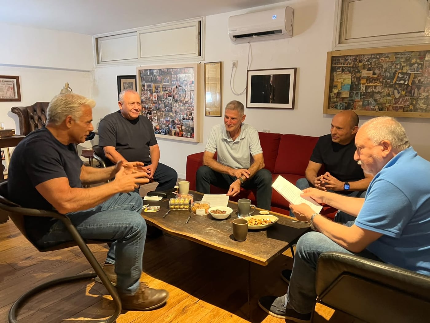Photographie originale de la réunion du 26 septembre 2026, 5 dirigeants de l'opposition israélienne assis autour d'une table basse dans un intérieur privé, en tee-shirts, polo et jeans